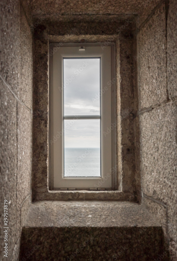 view of the ocean through a lighthouse window in the stone staircase view of the ocean through a lighthouse window in the stone staircase