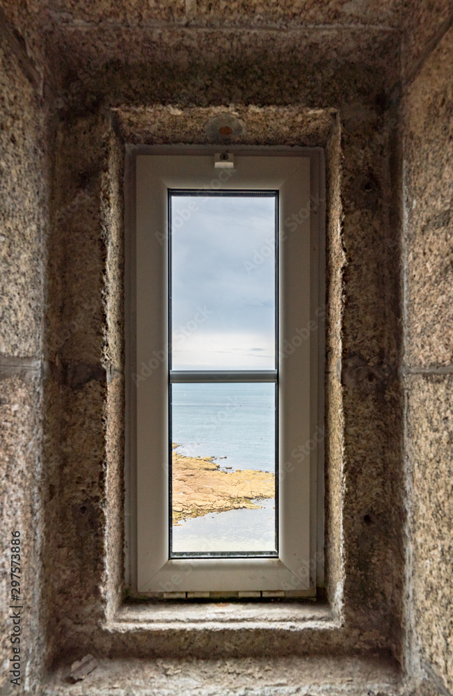 view of the ocean through a lighthouse window in the stone staircase view of the ocean through a lighthouse window in the stone staircase