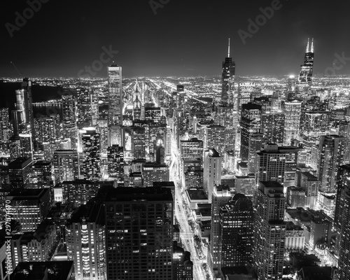 Filtered black and white image aerial view illuminated skyscrapers in downtown Chicago at dusk
