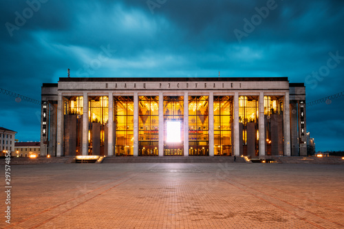 Minsk, Belarus. Building Of The Palace Of Republic In Oktyabrskaya Square In Evening Night Illuminations. Famous Landmark