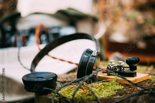 Russian Soviet Portable Radio Transceiver Used By USSR Red Army Signal Corps In World War Ii. Headphones And Telegraph Key Are On A Forest Stump photo