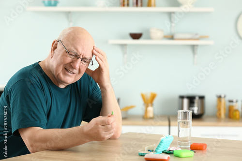 Elderly man with pills at home