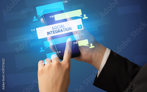 Canvas-taulu Female hand typing on smartphone with SOCIAL INTEGRATION inscription, social net