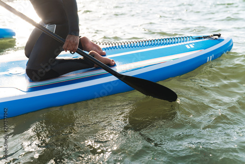 Cropped image of woman working out with stand up paddle board © Drobot Dean