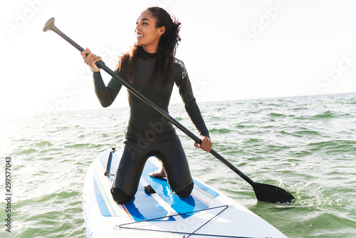 Image of smiling woman working out with stand up paddle board