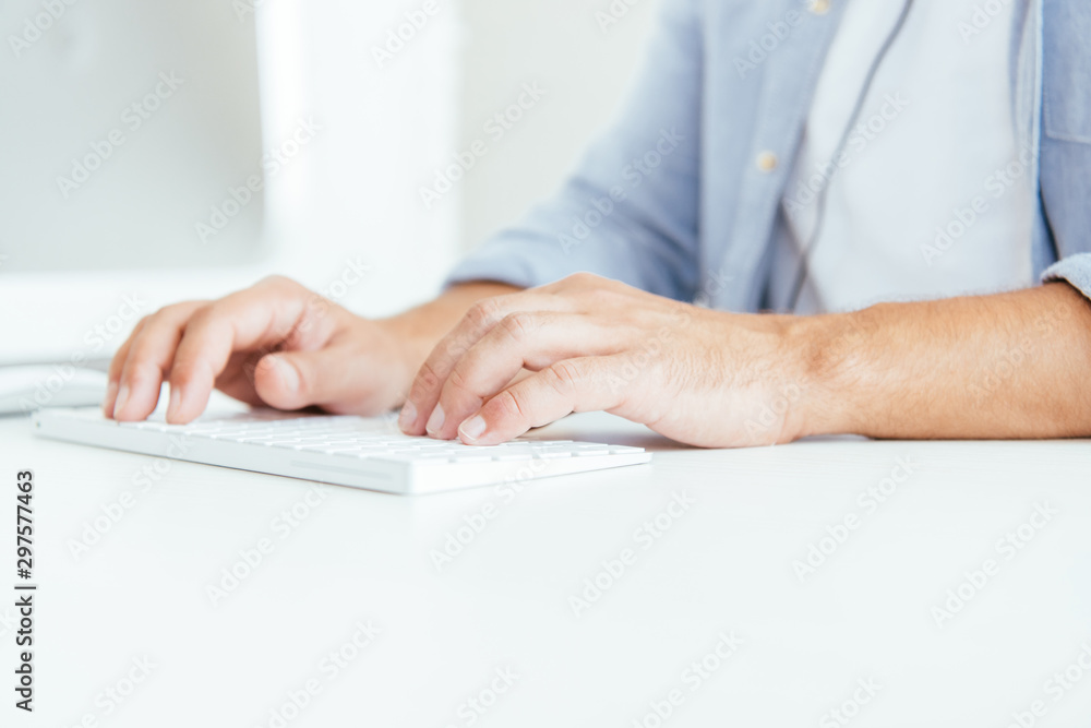 cropped view of broker typing on computer keyboard in office cropped view of broker typing on computer keyboard in office