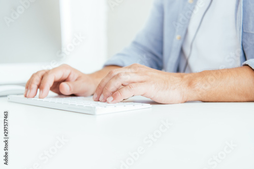 cropped view of broker typing on computer keyboard in office