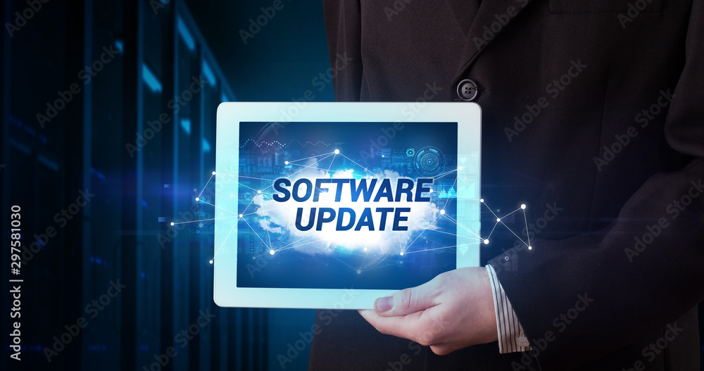Young business person working on tablet and shows the inscription: SOFTWARE UPDATE Young business person working on tablet and shows the inscription: SOFTWARE UPDATE