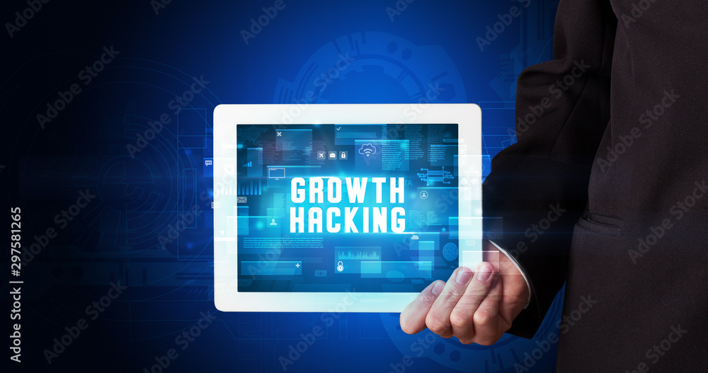 Young business person working on tablet and shows the digital sign: GROWTH HACKING Young business person working on tablet and shows the digital sign: GROWTH HACKING