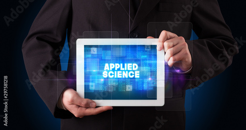 Young business person working on tablet and shows the inscription: APPLIED SCIENCE