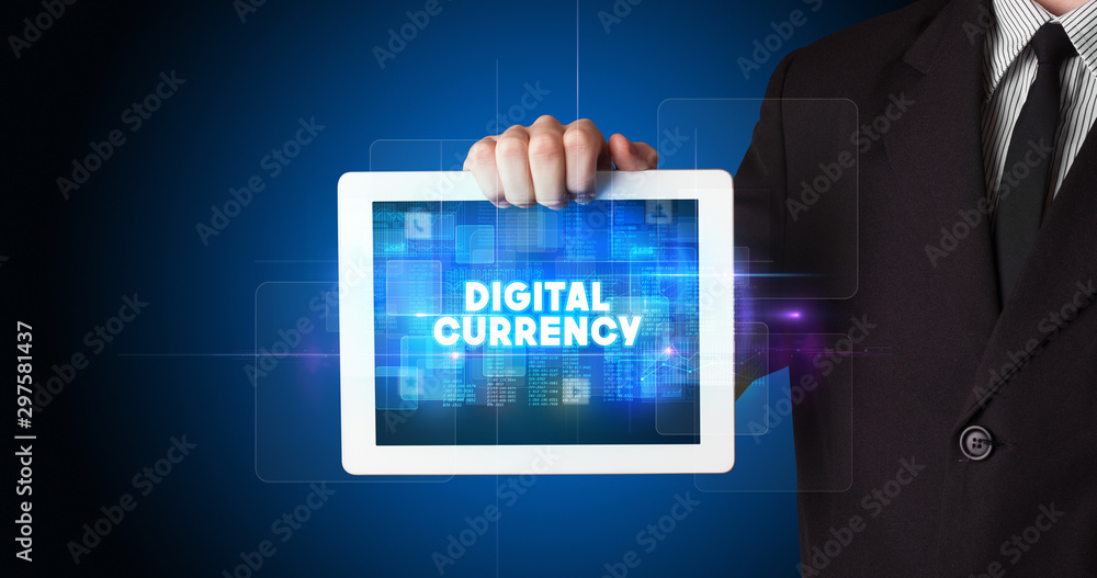 Young business person working on tablet and shows the inscription: DIGITAL CURRENCY Young business person working on tablet and shows the inscription: DIGITAL CURRENCY
