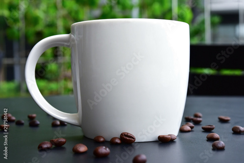 C๊Up of Coffee on the of dark wood table have many coffee beans. photo