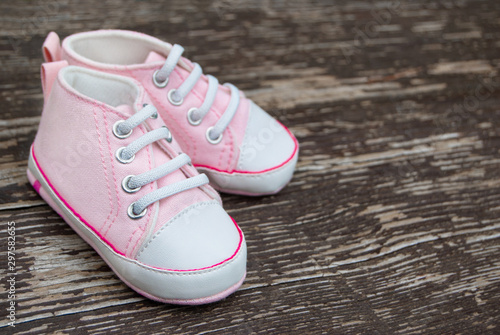 Baby girl pink shoes on wooden background