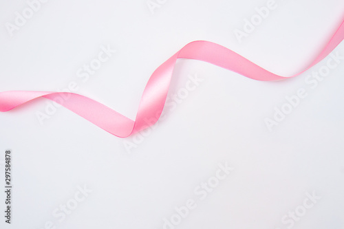 Φωτογραφία Curled pink ribbon with highlights isolated on white background, top view