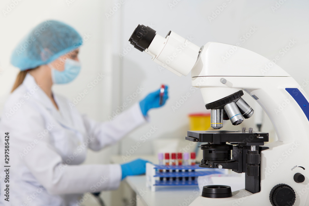 Woman researcher in laboratory testing samples on white blood cells Woman researcher in laboratory testing samples on white blood cells