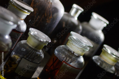Set of alchemy bottles in laboratory of alchemist. Herb in old pots with dust on  the glass surface.Alchemy symbol and objects. Poison and elixir in glass jar. Set of vessel, ampulla, flask,drink.....
