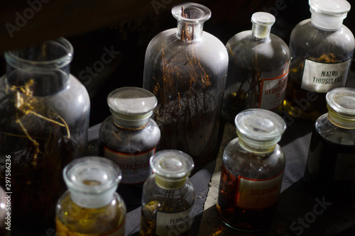 Set of alchemy bottles in laboratory of alchemist. Herb in old pots with dust on  the glass surface.Alchemy symbol and objects. Poison and elixir in glass jar. Set of vessel, ampulla, flask,drink.....