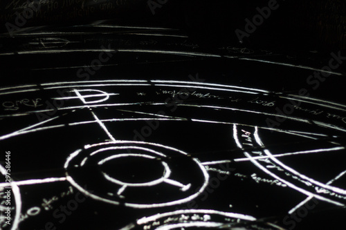  Black floor with alchemy symbol.  Mysterious scheme on dark background. Mystery signs of hermetic art. Witchcraft, devilry, necromancy, diablerie, diabolism, devilment, sorcery, wizardry, witchery. 