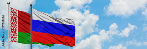 Belarus and Russia flag waving in the wind against white cloudy blue sky together. Diplomacy concept, international relations.