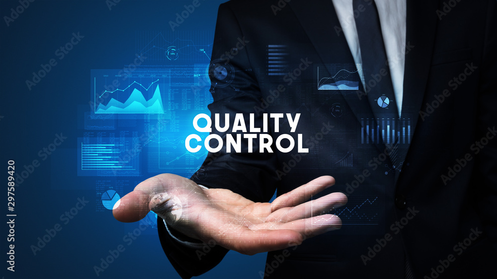 Hand of Businessman holding QUALITY CONTROL inscription, business success concept Hand of Businessman holding QUALITY CONTROL inscription, business success concept