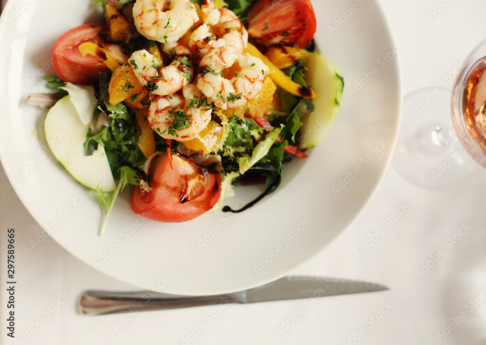 Delicious fresh shrimp salad with grilled shrimps, greens, slices of tomatoes, pear, nuts dressed with balsamic vinegar and olive oil. Healthy food and diet. Perfect tasty lunch or brunch. Seafood. Delicious fresh shrimp salad with grilled shrimps, greens, slices of tomatoes, pear, nuts dressed with balsamic vinegar and olive oil. Healthy food and diet. Perfect tasty lunch or brunch. Seafood.