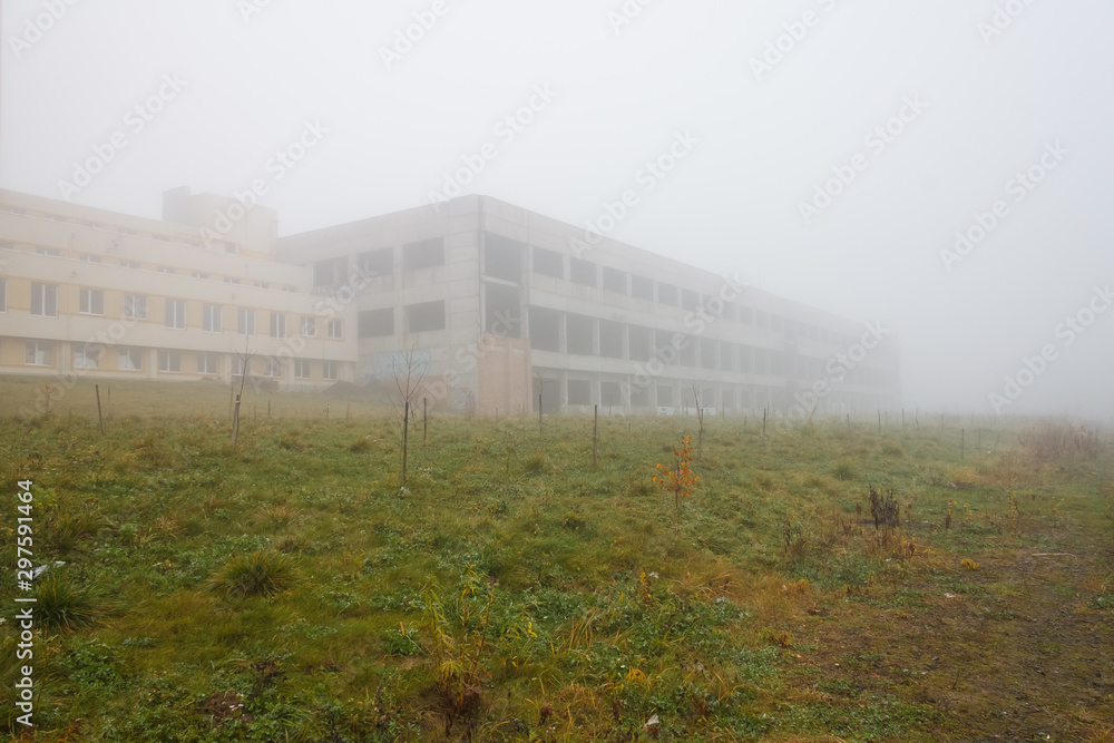 Multi-storey house in thick fog. Autumn landscape