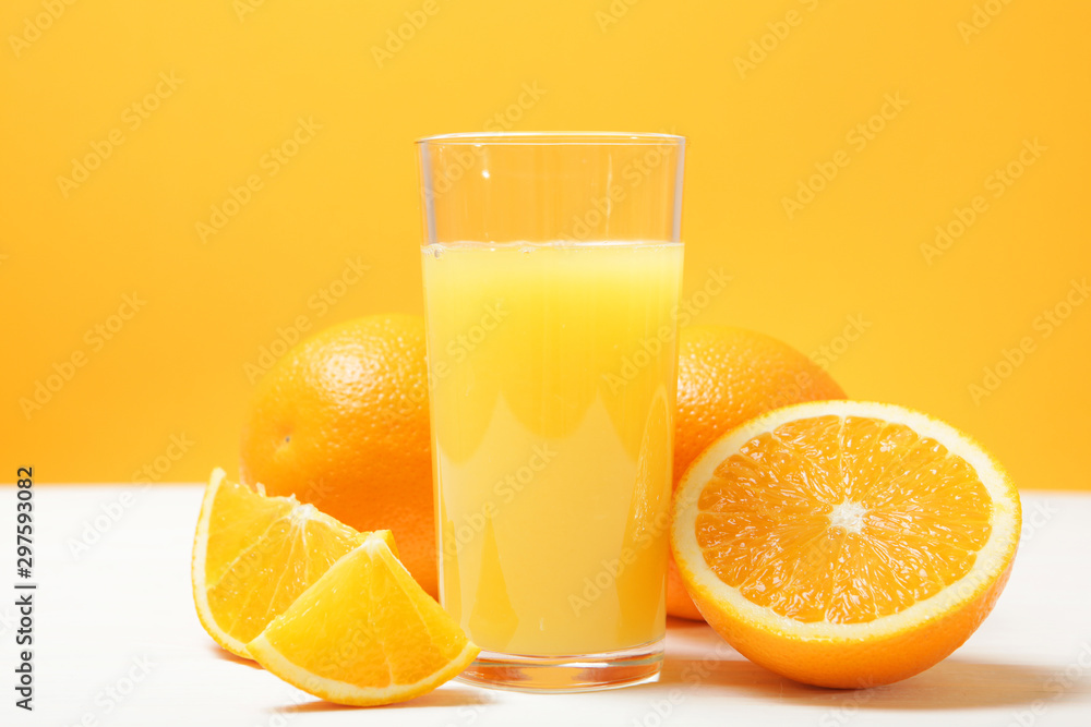 Orange juice in a glass, oranges and orange slices on the table. Orange juice in a glass, oranges and orange slices on the table.