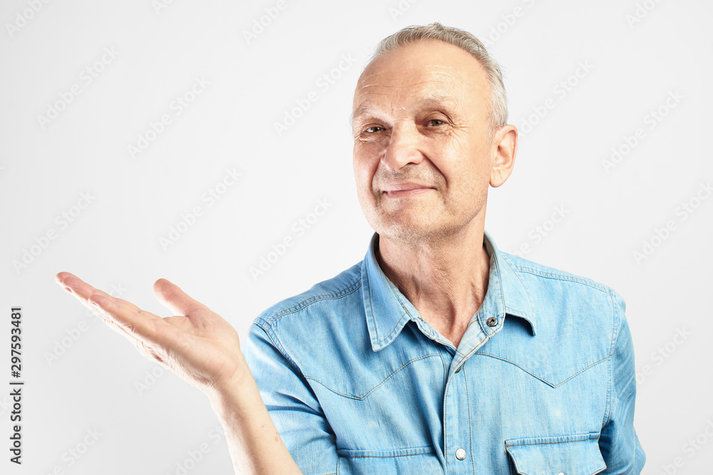 Positive gray-haired grandfather smile pretending to be holding something in palm of hand in white studio isolated with copy space Positive gray-haired grandfather smile pretending to be holding something in palm of hand in white studio isolated with copy space
