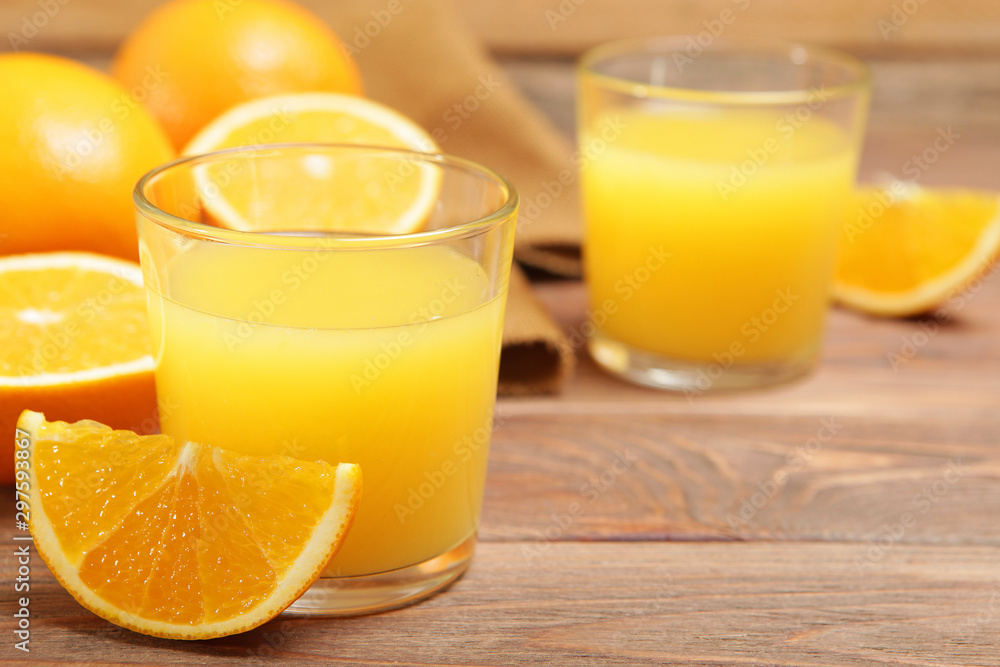 Orange juice in a glass, oranges and orange slices on the table. Orange juice in a glass, oranges and orange slices on the table.