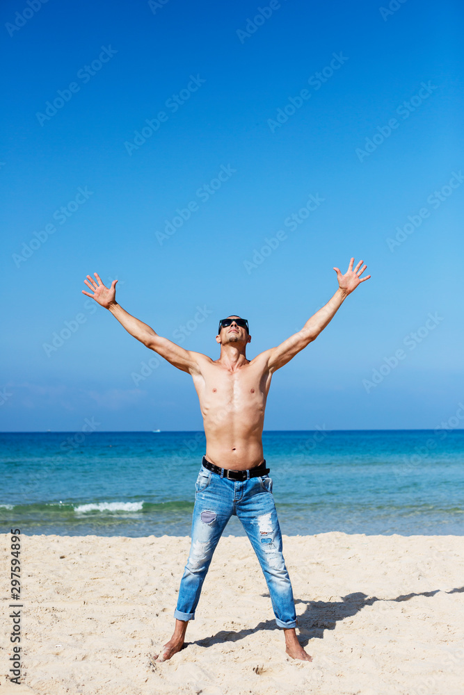 young muscular man resting and posing on the beach young muscular man resting and posing on the beach