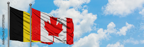 Belgium and Canada flag waving in the wind against white cloudy blue sky together. Diplomacy concept, international relations.