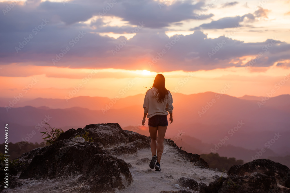 Slim beautiful girl walks mountains at sunset