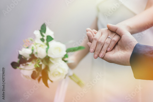 Close-up image of the groom holding the bride s hand with the ring on the hand.
