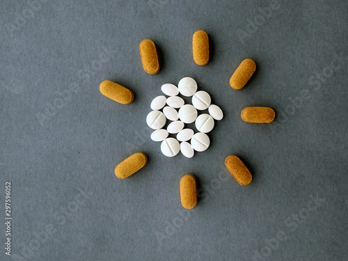 Obraz na płótnie photo white pills laid out in the shape of the sun on a blue background w salonie
