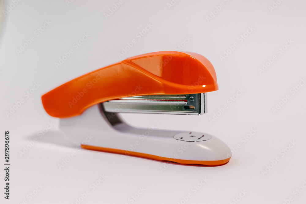 orange paper stapler on a white background. orange paper stapler on a white background.