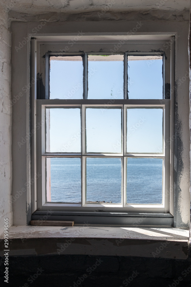 Fototapeta premium window looking out to sea at Point Prim Light House Museum in PEI