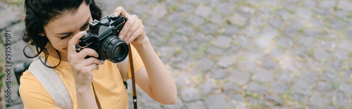 panoramic shot of woman taking photo on digital camera