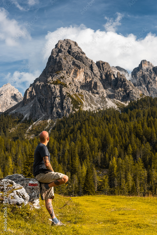 Adventure Man sSitting on Rock after Solo Hiking Dolomites Mountains