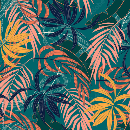 Fashionable seamless tropical pattern with bright blue and yellow plants and leaves on green background. Beautiful print with hand drawn exotic plants. Seamless pattern with colorful leaves and plants