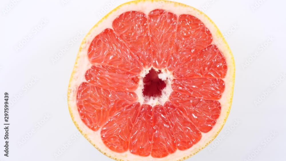 Fresh half of grapefruit citrus fruit on plate rotating. Healthy eating, weight loss, light meal. Top view Fresh half of grapefruit citrus fruit on plate rotating. Healthy eating, weight loss, light meal. Top view