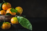 Tangerines with leaves on an old fashioned country table. Selective focus. Horizontal.
