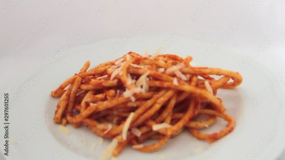 1flying over a plate of bucatini amatriciana with a drop of pecorino cheese 1flying over a plate of bucatini amatriciana with a drop of pecorino cheese
