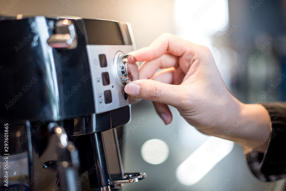 Male barista hand turning button on coffee machine in the kitchen. Making coffee concept Male barista hand turning button on coffee machine in the kitchen. Making coffee concept