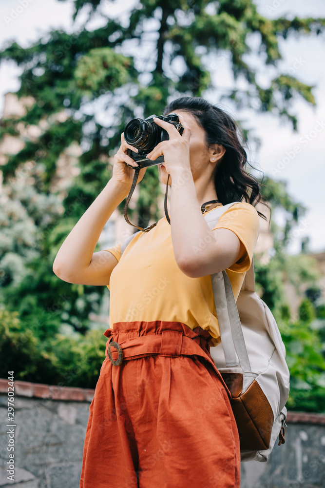 low angle view of girl holding digital camera while taking photo low angle view of girl holding digital camera while taking photo