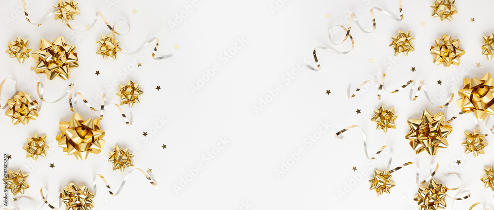 Christmas or New Year composition with gold sparkling ribbon decorations on white background. Flat lay, copy space. - obrazy, fototapety, plakaty 