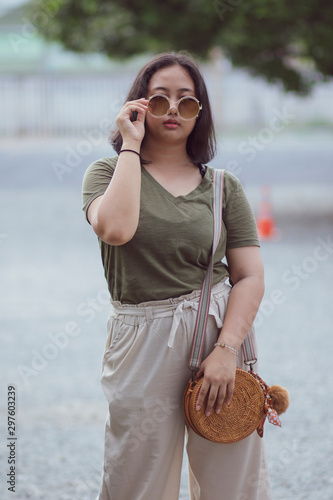 asian teenager wearing sun glasses standing with self confidence photo