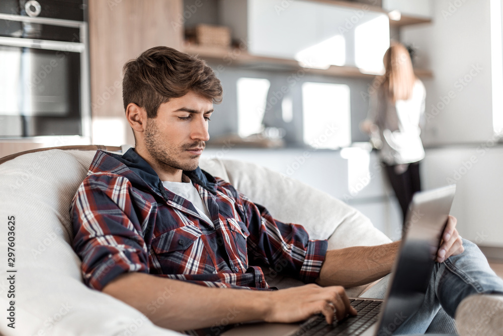 side view. successful young man with laptop sitting in chair side view. successful young man with laptop sitting in chair