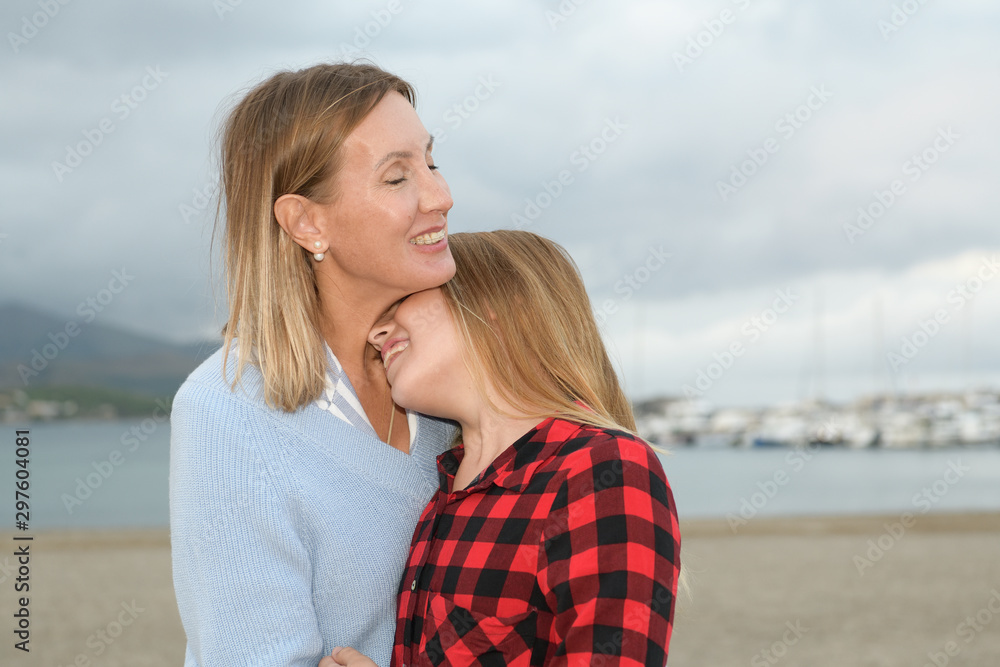 Mother and daughter hugged and happy show their affection next to the sea Mother and daughter hugged and happy show their affection next to the sea