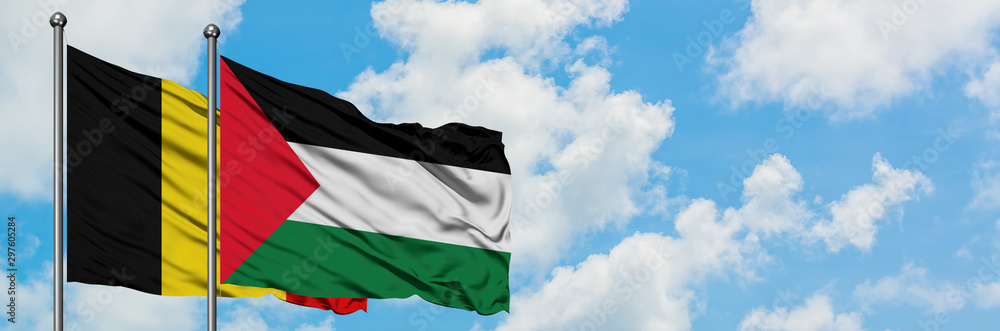 Obraz premium Belgium and Palestine flag waving in the wind against white cloudy blue sky together. Diplomacy concept, international relations.