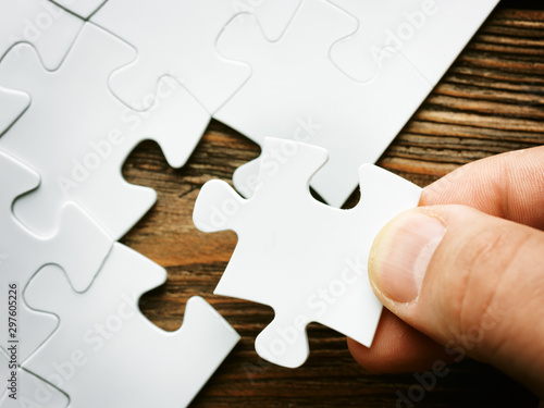 Hand with missing jigsaw puzzle piece. Business concept image for completing the final puzzle piece